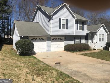Charming two-story home with a two-car garage and traditional siding and landscaping at 1574 Elizabeth Ln, Hampton, GA 30228