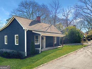 Charming blue home featuring a cozy front porch and well-maintained landscaping at 340 Cedar St, Social Circle, GA 30025