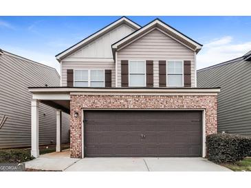 Charming two-story home features a brick facade, two-car garage and a welcoming covered entryway at 323 Lauren Dr, Fairburn, GA 30213