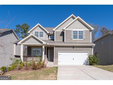 Charming two-story home with attached two car garage, beautiful landscaping and covered front porch at 7754 Hansel Ln, Lithonia, GA 30058