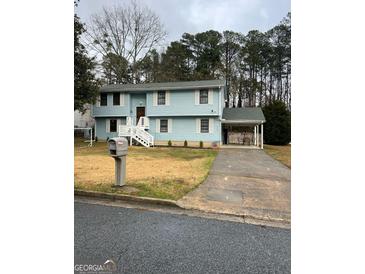 Charming two-story home with light blue siding, white trim, and a well-maintained front yard at 5865 Vernier Dr, Atlanta, GA 30349