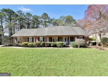 Beautiful brick home with manicured lawn and lush landscaping creating great curb appeal at 3075 Wood Valley Dr, Mcdonough, GA 30253