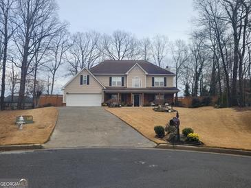 Charming two-story home featuring a manicured lawn, inviting entrance, and attached two-car garage at 4006 Asheville Ct, Buford, GA 30519