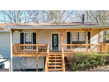 Charming home featuring a cozy front porch with wooden rails and steps leading to the entrance at 6255 James Rd, Austell, GA 30168