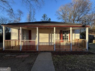 Charming home featuring a cozy front porch and freshly painted red and white trim, offering a warm and inviting curb appeal at 18 Laurel St, Covington, GA 30014