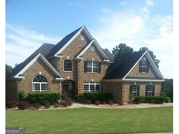 Charming two-story brick home with well-manicured lawn, mature landscaping, and classic architectural details at 3801 Gold Leaf Ct, Stockbridge, GA 30281