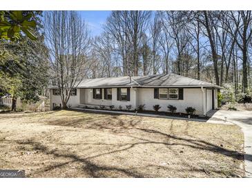 Charming single-story home with a brick exterior, black shutters, and mature trees in a quiet neighborhood at 5595 Richland Dr, Douglasville, GA 30135