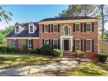 Charming two-story brick home featuring black shutters, a manicured lawn, and a welcoming front entrance at 105 Windridge Dr, Fayetteville, GA 30215