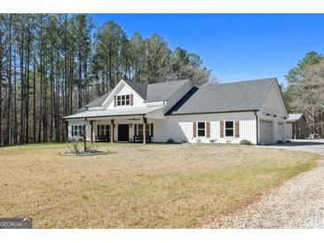 Charming white farmhouse with a gray roof, dark shutters, and a welcoming front porch at 1185 Old Greenville Rd, Fayetteville, GA 30215