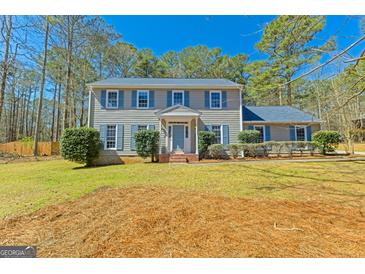 Charming two-story home with gray siding, blue shutters, manicured lawn, and inviting entryway at 175 Ashley Dr, Fayetteville, GA 30214