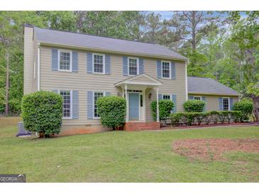 Charming two-story home with blue shutters, a well-manicured lawn, and a welcoming front entrance at 175 Ashley Dr, Fayetteville, GA 30214