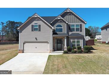 Charming two-story home with a two-car garage and well-manicured lawn in a residential neighborhood at 7019 Diamond Dr, Rex, GA 30273
