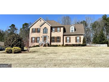 Traditional two-story brick home with brown shutters and a manicured front lawn on a sunny day at 345 Gaelic Way, Tyrone, GA 30290