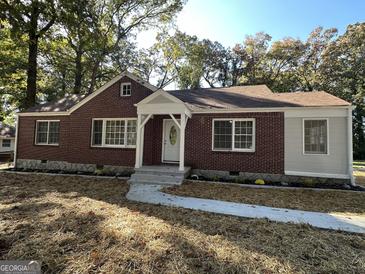 Charming brick home featuring manicured landscaping and freshly laid straw at 718 N Hairston Rd, Stone Mountain, GA 30083