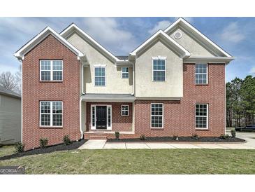 Two-story brick and siding home with a black front door and manicured lawn at 253 Summit View Dr, Mcdonough, GA 30253