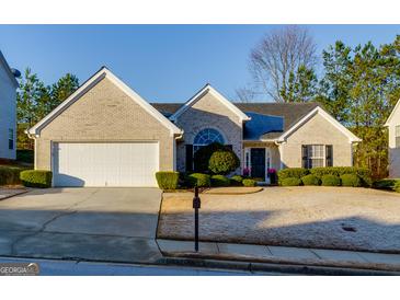 Charming single-story home with a white brick exterior, well-manicured lawn, and attached two-car garage at 4030 Cresent Walk Ne Ln, Suwanee, GA 30024