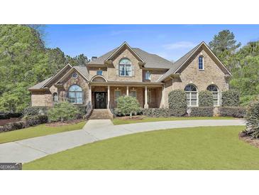 Stunning brick home features a covered front porch, beautiful landscaping, and a curved driveway at 310 Westbourne Dr, Tyrone, GA 30290