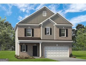 Two-story brick home featuring a two-car garage, black shutters, and a well-manicured lawn at 10453 Trellis Lane (Lot 28), Hampton, GA 30228
