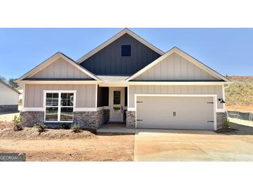 Charming home features a two-car garage, beautiful stonework, and an inviting front porch at 481 Cantrell Drive, Dallas, GA 30157