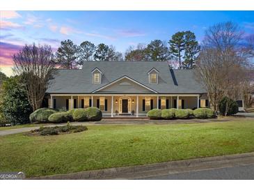 Traditional home boasting symmetrical design, dormer windows, dark shutters and meticulously maintained landscaping at 122 Lawn Market, Sharpsburg, GA 30277