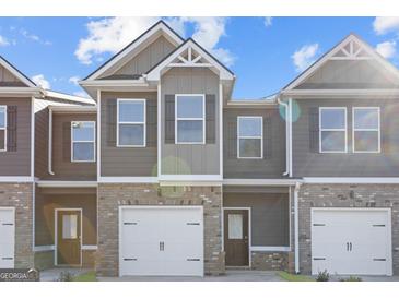 Newly constructed townhome features a brick facade, attached garage, and covered entryway at 223 Ivey Ter # 34, Temple, GA 30179
