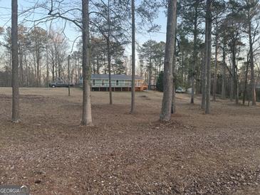Charming single-level home with a deck, surrounded by a wooded landscape, sitting away from the road at 4864 Yeagar Rd, Douglasville, GA 30135