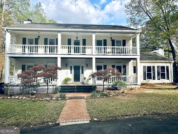 Charming two-story home with a double porch, black shutters, and lovely landscaped yard at 114 Rolling Grn, Peachtree City, GA 30269
