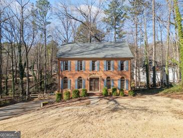 Charming two-story brick home featuring blue shutters and lush landscaping at 505 Summer Ter, Woodstock, GA 30189