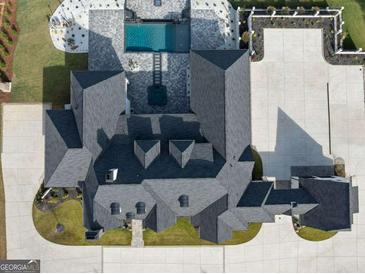 An aerial view of a luxury home featuring a pool, manicured lawns, and a circular driveway at 4100 Oak Hill Rd, Douglasville, GA 30135