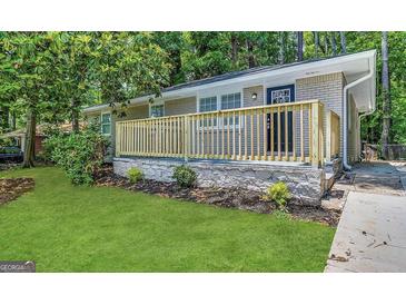 Charming single-story home featuring a brick facade, a new wooden porch, and a well-manicured front lawn at 4352 Glenwood Pkwy, Decatur, GA 30032