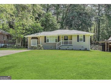 Charming single-story home featuring a well-manicured lawn and inviting front porch at 1908 S Columbia Pl, Decatur, GA 30032