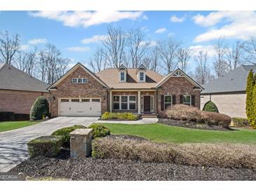 Charming brick home featuring a manicured lawn and a two-car garage at 4930 Cecilia Sq, Cumming, GA 30040