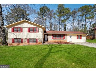 Charming split-level home featuring a well-maintained lawn and inviting curb appeal in a tree-lined neighborhood at 131 Heron Dr, Riverdale, GA 30274