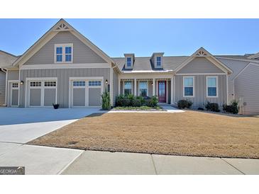 Charming single-story home with a gray exterior, well-manicured lawn, and an attached two-car garage at 135 Red Maple Dr, Peachtree City, GA 30269