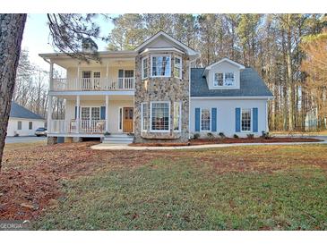 Inviting two-story home featuring a stone accent wall, double decks, and a well-maintained front yard at 215 Farr Lake Dr, Tyrone, GA 30290