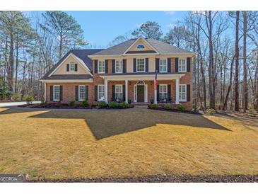 Beautiful two-story brick home with a welcoming front porch and well-manicured lawn at 125 Tall Timber Ct, Fayetteville, GA 30215