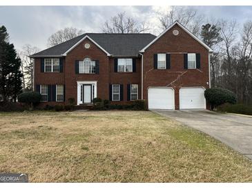 Charming two-story brick home with a two-car garage and traditional architectural details at 11 Carriage Lake Dr, Stockbridge, GA 30281