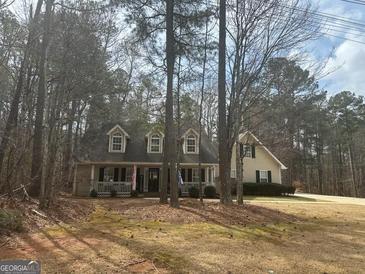 Inviting home with dormers and a welcoming front porch surrounded by mature trees at 3213 Sweetbriar Dr, Villa Rica, GA 30180