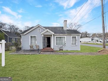 Charming single-story home featuring a well-manicured lawn and inviting front porch at 1683 Candler Rd, Decatur, GA 30032