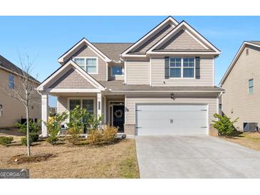 Charming two-story home boasts neutral siding, a two-car garage, and a well-maintained front lawn at 2361 Hanover Woods Rd, Lithonia, GA 30058