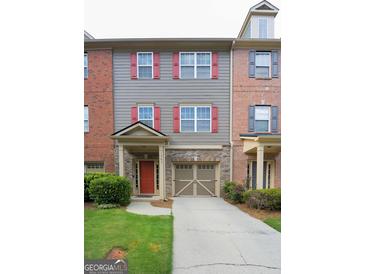 Charming townhome with a brick and gray exterior, complete with a one car garage and colorful shutters at 1383 Dolcetto Nw Trce # 9, Kennesaw, GA 30152