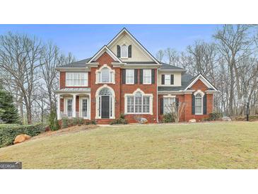 Stunning brick home with a meticulously maintained lawn and mature trees surrounding the property at 1133 Astoria Ln, Peachtree City, GA 30269