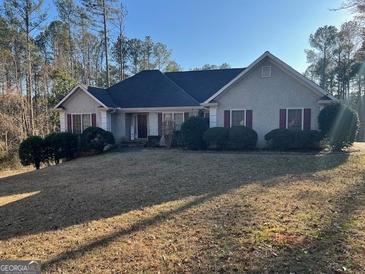 Traditional one-story home featuring a well-manicured lawn and mature landscaping, offering great curb appeal at 135 Lucky Leaf Pl, Fayetteville, GA 30214