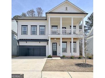 Charming two-story home with a welcoming front porch and a two-car garage, offers a blend of classic and modern architecture at 446 Bandon Way, Peachtree City, GA 30269