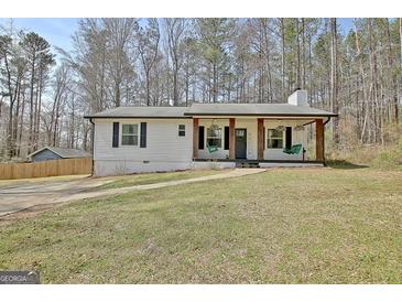 Charming home featuring a covered front porch with decorative hanging plants and classic black shutters at 1120 Minix Rd, Sharpsburg, GA 30277