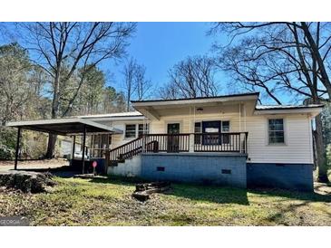 Charming single-story home featuring a front porch and carport on a sunny day at 121 Flat Rock Rd, Villa Rica, GA 30180