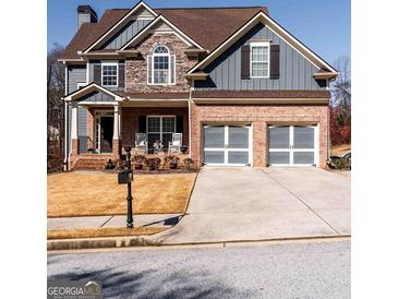 Charming two-story home with a well-manicured lawn and two-car garage at 9989 Village South Dr, Douglasville, GA 30135