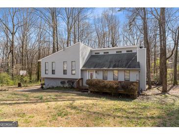 Charming exterior elevation of a two-story home with a low-profile deck and wooded surroundings at 3747 Junior Ln, Douglasville, GA 30135