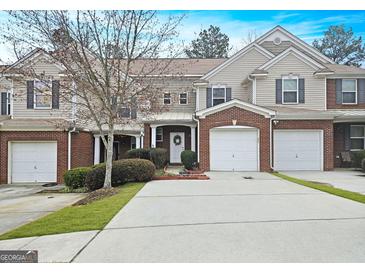 Charming townhome with a brick facade, attached garage, and well-maintained landscaping at 102 Ellis Dr, Conyers, GA 30012