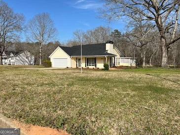 View of the home showing its neutral siding and large front yard at 328 Cattlemans Cir, Mcdonough, GA 30252